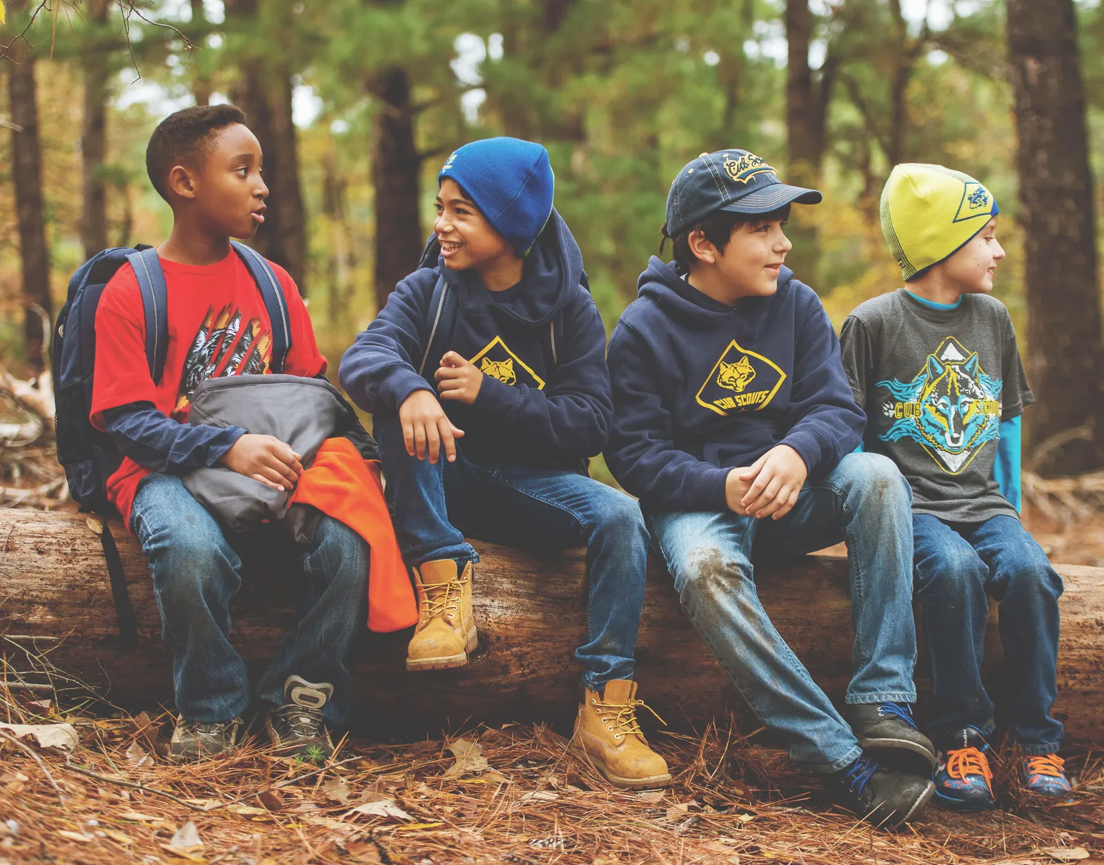 Cub Scouts resting on a log during an autumn hike